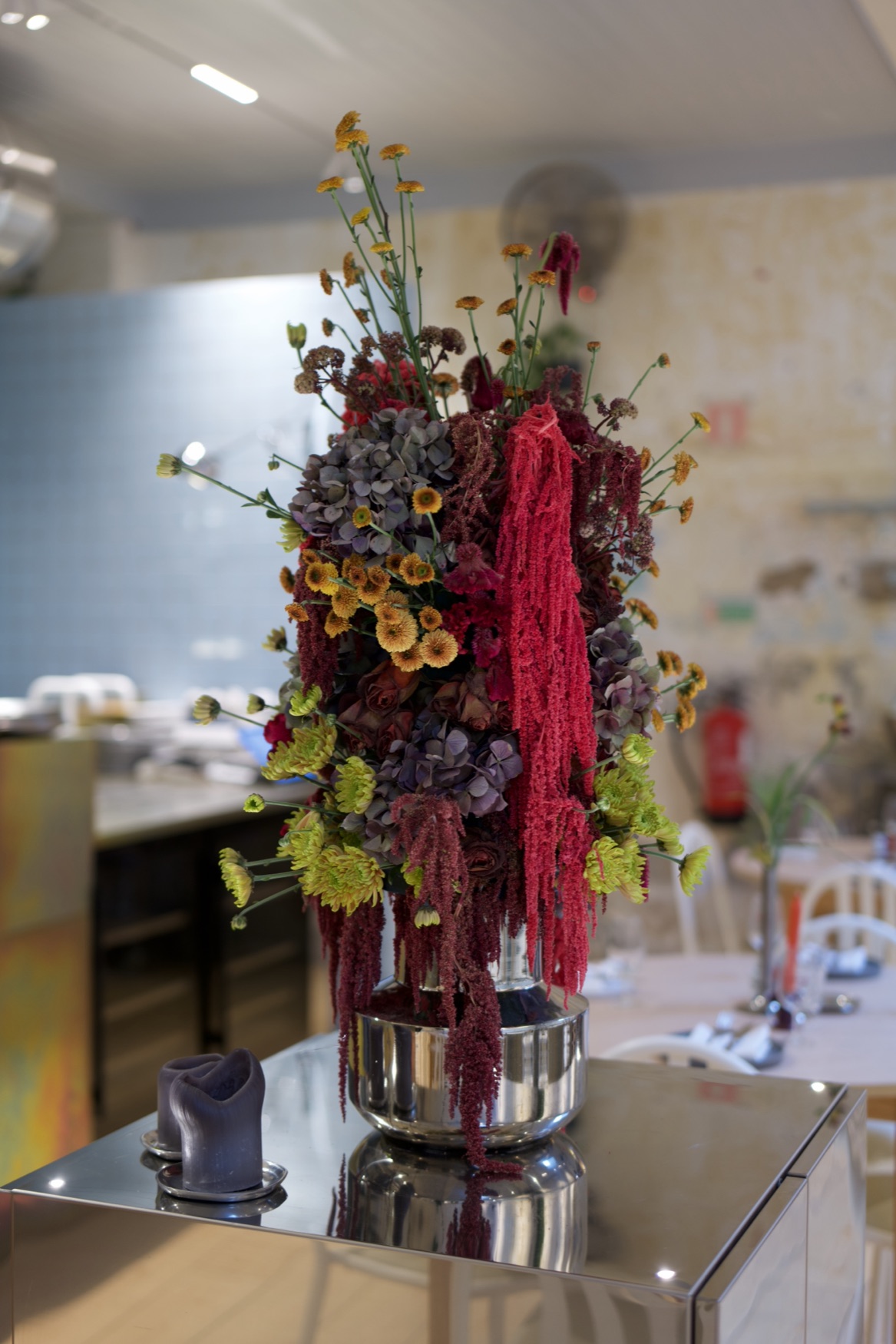 Dried flowers on a mirrored table at a dinner venue
